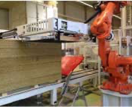 Ein großer orangener Roboterarm wird in voller Größe in einer Produktionshalle dargestellt.